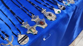 Exquisite Tuareg and Berber jewelry and amulets showcased on a blue cloth at a local market in Djanet, Algeria, set against the backdrop of the vast Saharan desert - Powered by Shutterstock - Get 15% off with code: PIKWIZARD15
