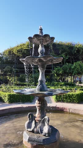 Elegant multi-tiered stone fountain in a lush garden