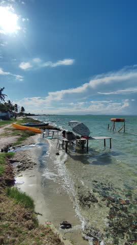 Boats and umbrela on the lake shore with trees in the background in a beautiful sunny and windy day
