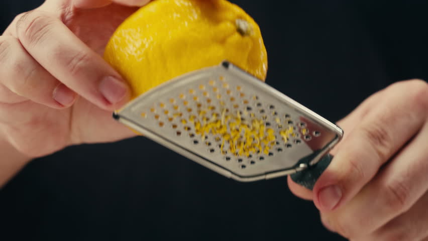 Lemon And Grater, Macro Close Up Shot of a Professional Chef Grating Lemon Zest for lemonade salad.