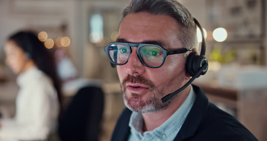 Call center, talking and consulting with business man in office for night, telemarketing or mortgage broker. Contact us, real estate advisor or communication with mature person at help desk agency