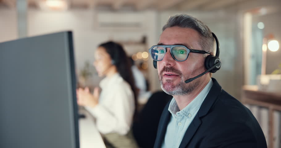 Call center, computer and night with business man in office for consulting, telemarketing or mortgage broker. Contact us, real estate advisor or communication with mature person pointing at help desk