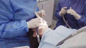 Professional medical expert performing precise dental treatment, examining patient's oral health using specialized dental equipment in modern clinical setting - Powered by Shutterstock - Get 15% off with code: PIKWIZARD15