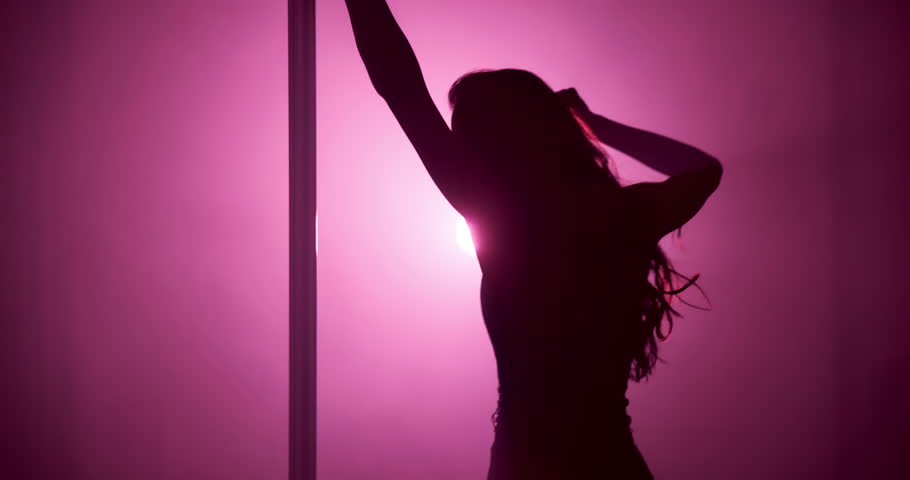 Woman, stage and pole dancer in shadow for dance, exotic performance and seduction in spotlight. Pink neon, aesthetic and performer in silhouette for burlesque, bright light or space in private venue