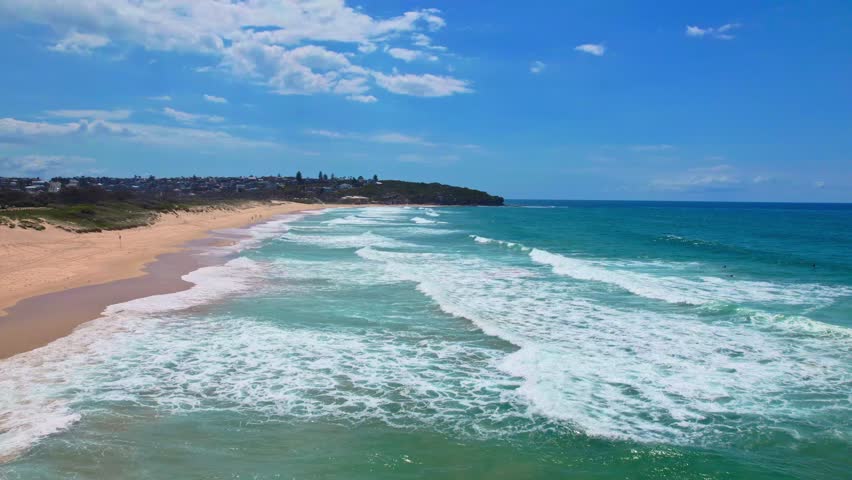 A stunning drone flight over Sydney's Curl Curl Beach on a bright summer day. This aerial view captures coastal perfection in Australia's iconic beach landscape.