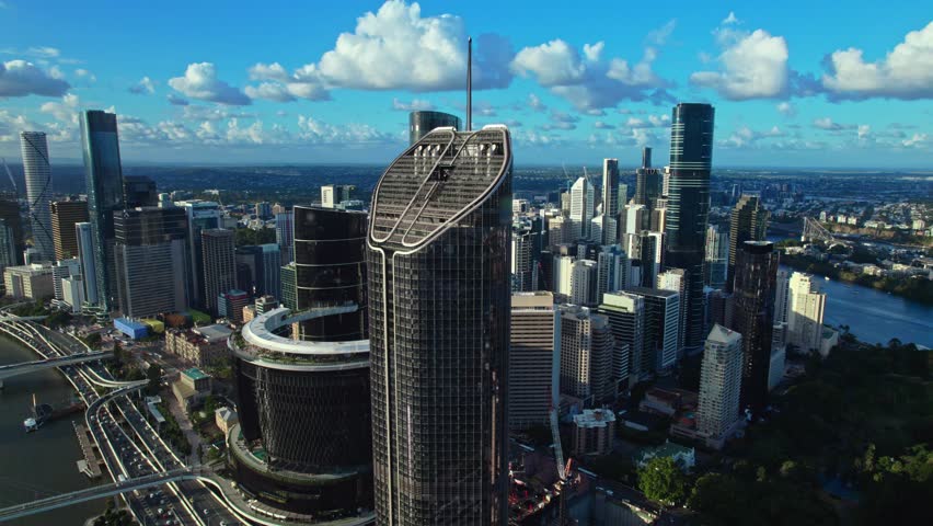 A stunning aerial view of Brisbane, Australia, showcasing the city's modern skyline, high-rise buildings, and bridges over the Brisbane River. The image captures the vibrant urban landscape