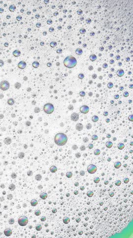 Foam background. Liquid soap bubbles, Froth bubbles backdrop. Soap foam popping bubble rotating, white backdrop. Soap sud macro structure close-up. Clean, cleaning, washing, laundry