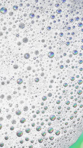 Foam background. Liquid soap bubbles, Froth bubbles backdrop. Soap foam popping bubble rotating, white backdrop. Soap sud macro structure close-up. Clean, cleaning, washing, laundry