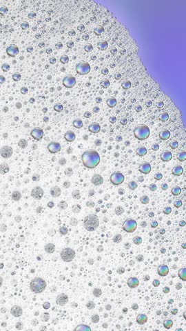 Foam background. Liquid soap bubbles, Froth bubbles backdrop. Soap foam popping bubble rotating, white backdrop. Soap sud macro structure close-up. Clean, cleaning, washing, laundry