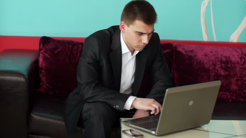 Businessman typing on notebook and looking away