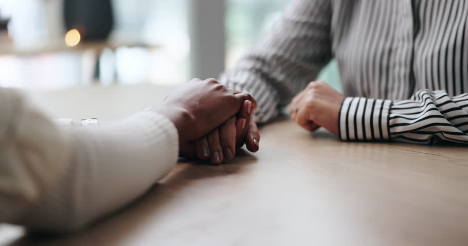 Therapist, people and holding hands for comfort, care and trust with kindness in clinic. Counseling, support and psychologist help with empathy for grief, console or connection with sympathy for loss