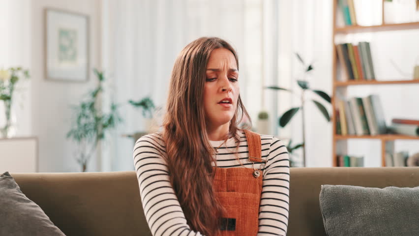 Sick, woman or cough with illness on sofa for chest pain, asthma or respiratory infection at home. Female person, cold or flu with symptoms of virus for pneumonia, sinus or allergy on couch at house