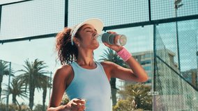 Tennis player, woman and drinking water on court for match recovery, workout hydration and practice break. Padel sports, athlete and liquid bottle for fitness refresh, thirsty or resting for wellness - Powered by Shutterstock - Get 15% off with code: PIKWIZARD15