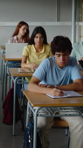 Vertical HD video of young group of diverse students studying at high school classroom. Education and back to school concept.