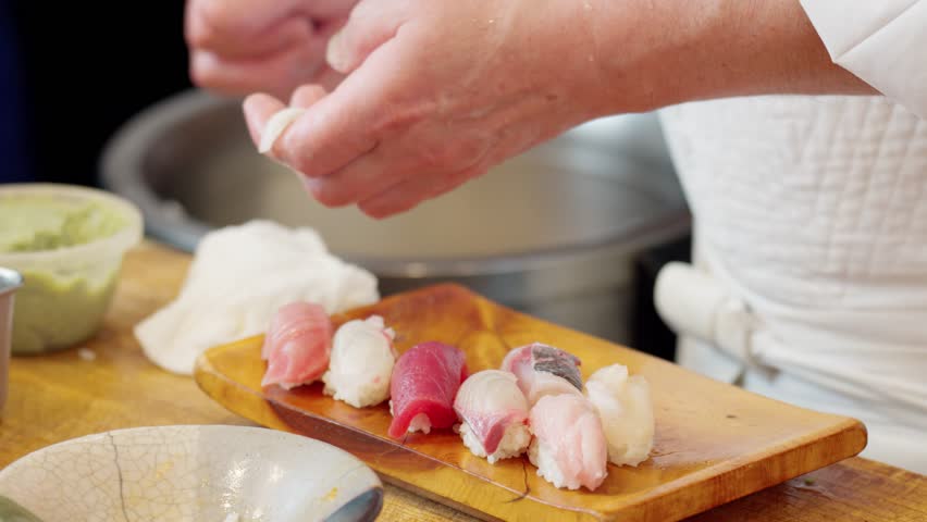The hands of a chef preparing sushi