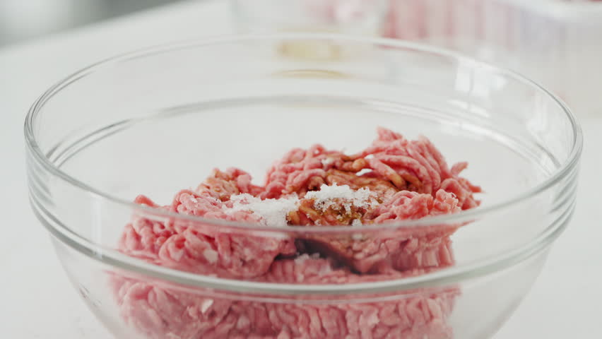 Seasoning ground beef with garlic, and chopped onion