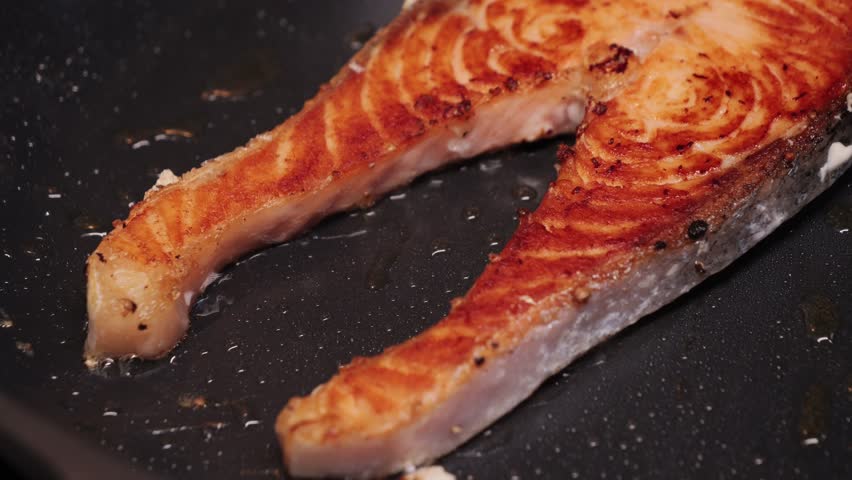 Grilled salmon fillet seasoned with black pepper cooked on a grill. Cooking salmon steak in a frying pan. Concept of seafood, healthy nutrition. High quality 4k footage
