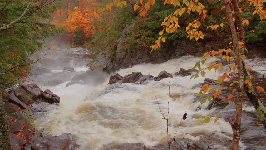 This stunning 4K footage captures Roaring Brook Falls, a waterfall in the Adirondacks, surrounded by vibrant green forests, showcasing the beauty of the area.