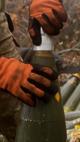 Vertical video. Military male preparing a shell for firing in a dense forest. Concept of military defense and military equipment.