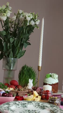 Festive Easter table with traditional food, flowers, and a lit candle beautifully arranged in a warm, homey setting