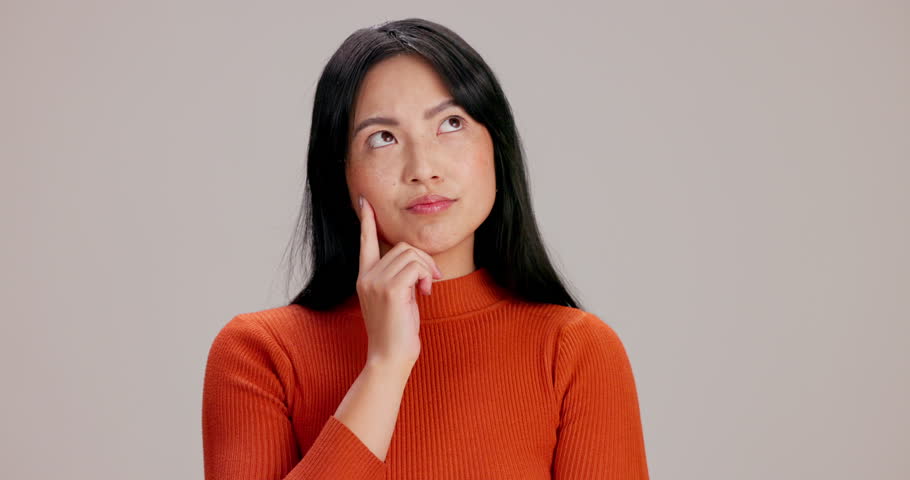 Thinking, idea and woman in studio with question, doubt or decision for career development. Choice, unsure and Japanese female person with solution, brainstorming or planning by gray background.