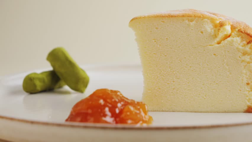 Close up of Japanese cheesecake fluffy on plate with jam. High quality 4k footage