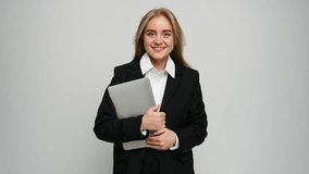 A confident young professional smiles with a laptop, dressed in modern business attire. - Powered by Shutterstock - Get 15% off with code: PIKWIZARD15