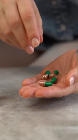 Female hands open jar and pour out pills into palm. Pills and drugs medicament vitamins. Take medicine take pill. Medicine and health care. Vertical shot