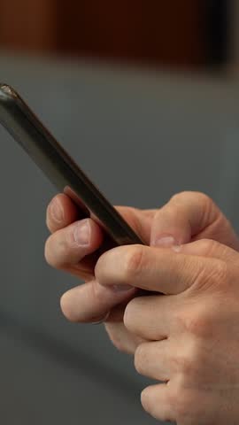 Men hands hold mobile phone. Social media searching information chatting online shopping surfing internet. Vertical shot