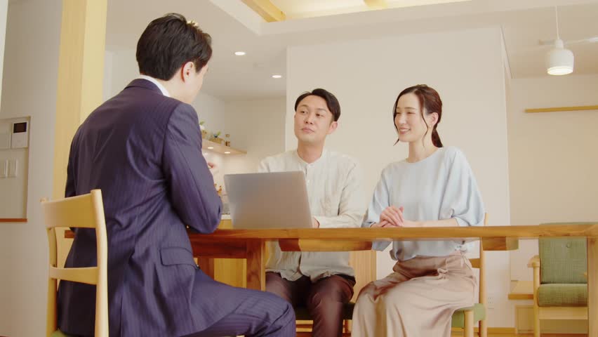 A couple being sold by a businessman in a suit