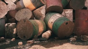 A collection of worn, rusty barrels is scattered on the ground, showing signs of age and neglect, near an industrial area, conveying a sense of abandonment and decay. - Powered by Shutterstock - Get 15% off with code: PIKWIZARD15