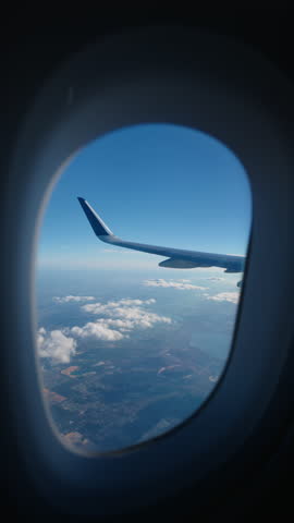 Vertical Screen: Experience breathtaking views from an airplane window as you soar through the sky, surrounded by vibrant colors of the skies and clouds during your inflight journey