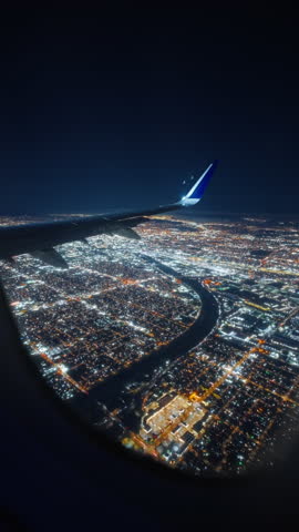Vertical Screen: This is a breathtaking view captured from an airplane window during a flight, showcasing the enchanting sky and fluffy clouds at night as the plane gracefully prepares for landing