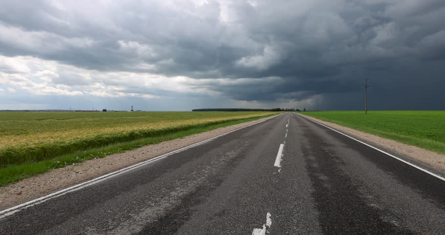 paved highway in cloudy weather, narrow rural paved road before a thunderstorm