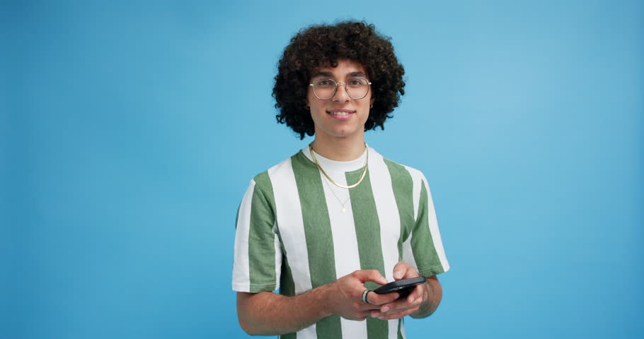 Studio, man and face with smartphone for chat, online communication and comment for digital reel. Mockup space, happy person and portrait with mobile app for social media, meme and blue background