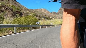 Close up slow motion capturing cyclist legs pedaling challenging uphill mountain road, revealing intense physical effort and unwavering athletic determination during demanding road cycling journey - Powered by Shutterstock - Get 15% off with code: PIKWIZARD15