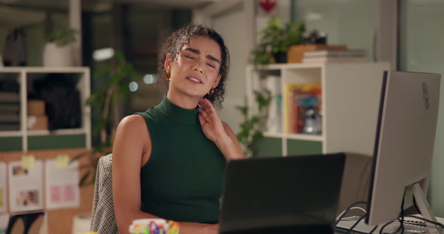 Computer, neck pain and stress with designer woman in office at night for project deadline. Exhausted, fatigue or tired with unhappy creative employee in workplace for programming or web development