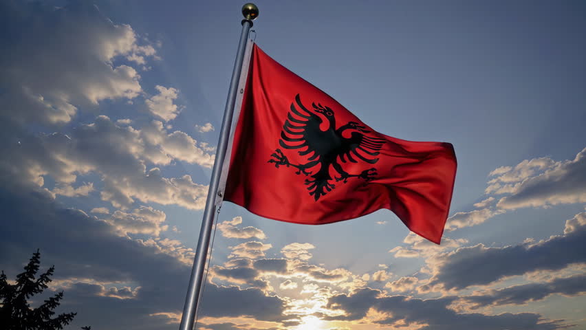 A vibrant Albanian flag beautifully waving in the sunset, representing national pride and cultural identity with grace