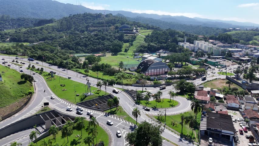 4K drone aerial view of the entrance to Mogi das Cruzes, SP, Brazil, on a sunny day. The video captures the cityscape, road infrastructure, and skyline of this key region in Alto Tietê