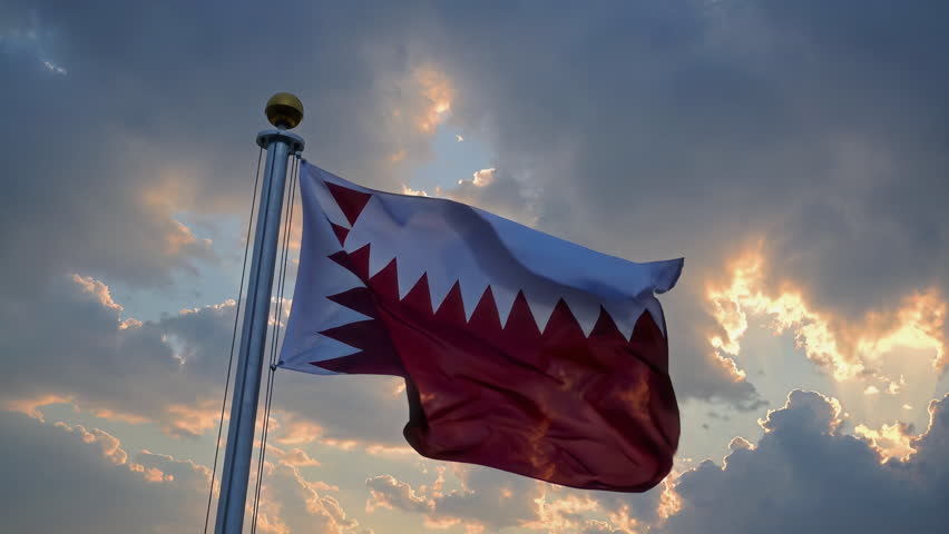 A stunning scene of the Qatari flag waving under a cloudy sky, symbolizing national pride and unity