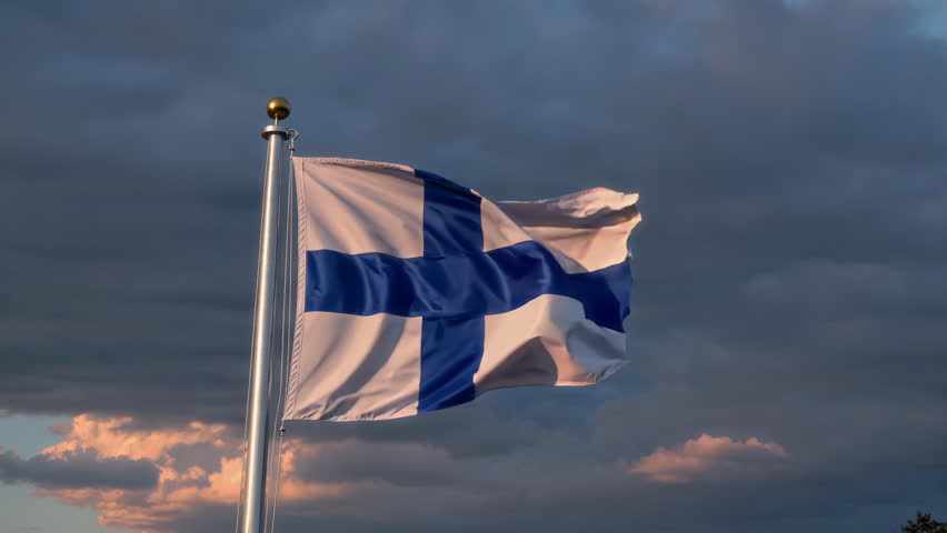 A vibrant flag of Finland proudly flutters gracefully against a dynamic and cloudy backdrop, showcasing national pride