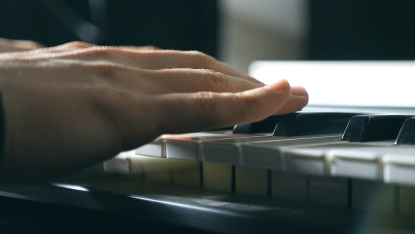 Close up fingers of pianist at the piano keys. Mens arms plays solo of music or new melody. Hands of male musician playing at synthesizer. Slow motion Top view Isolated shot