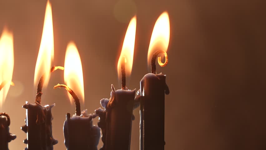 Candles flicker in a vintage menorah, casting a warm glow during the Hanukkah celebration. Delicious sufganiyah awaits on the table, symbolizing tradition and cultural heritage in Jewish faith.