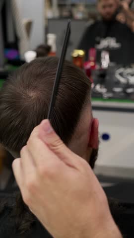 Barbershop. Unrecognizable male barber hands making customer Fashionable haircut in Modern style barber shop. Bearded Man client visit gentleman grooming beauty salon for hairstyle care