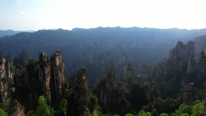 Aerial dolly right shot revealing sunbeams at the top of Tianzi Mountain in Zhangjiajie National Forest Park, China