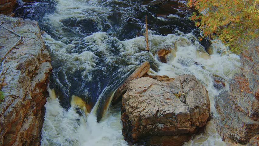 Gorgeous 4K aerial footage of a mountain creek and waterfall in the Adirondacks, set against the backdrop of vibrant autumn foliage, capturing the essence of fall in the wild.