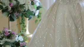 A beautiful wedding dress with a long, lace-trimmed train is displayed on a mannequin. The scene is decorated with flowers and ornate pedestals, creating a romantic atmosphere. - Powered by Shutterstock - Get 15% off with code: PIKWIZARD15