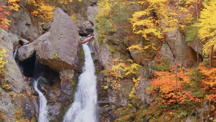 A beautiful view of Bash Bish Falls, the highest waterfall in Massachusetts, situated in Bash Bish Falls State Park, framed by vibrant autumn foliage.