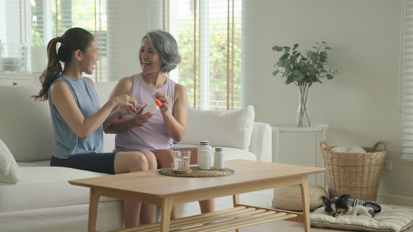 Young adult child give advice to middle age old mum. Love health care older aged mom asia elder people at home happy family help protect aging asian life. Vitamin d c e k zinc omega 3 fish oil pill.