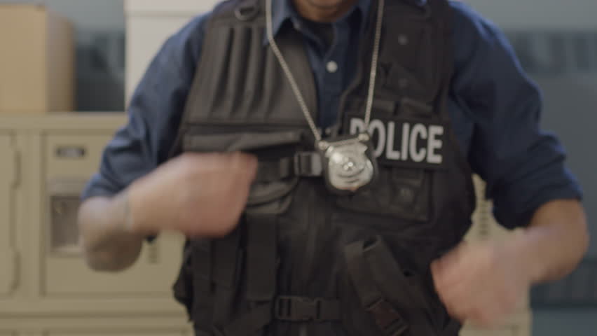 Police officer with badge walking off camera